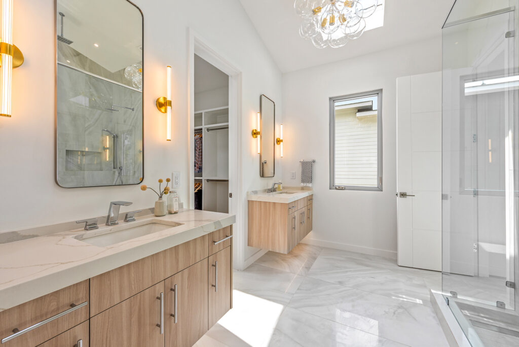 large format porcelain tile in a modern bathroom with double vanities and a walk in shower